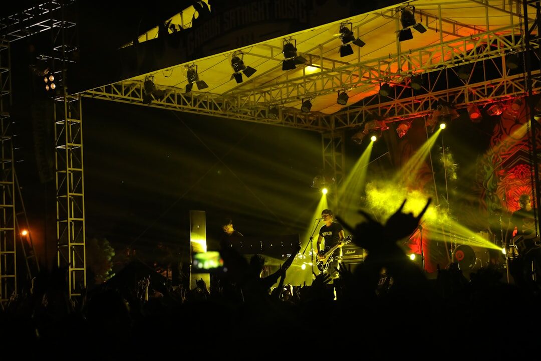 Concert stage with dramatic colored lighting and silhouettes of performers